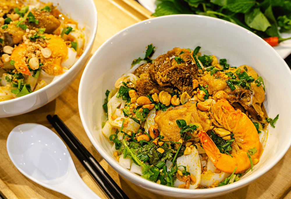 Illustration of an eye-catching bowl of Quang noodles with delicious, attractive flavors at Mi Quang Thi (Source: Canva)